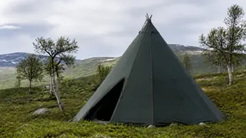 Mørkegrønn lavvo med barduner i et norsk fjellandskap
