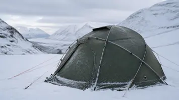 Robust kuppelformet vintertelt med kryssende stenger og barduner i snø